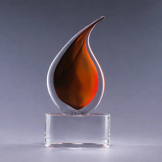 Decorative glass sculpture with a flame-like design on a clear base against a gray background