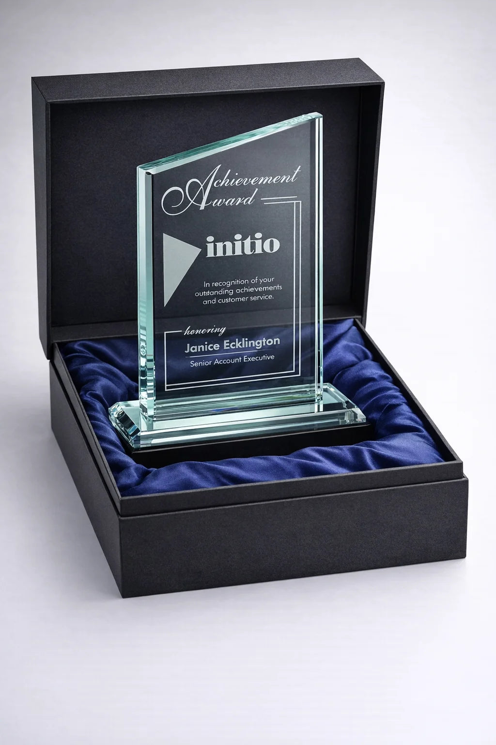 Glass award in a black box with blue lining, featuring the 'initio' brand.