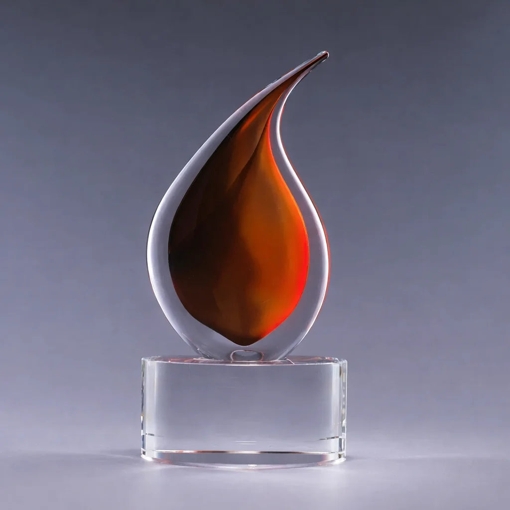 Decorative glass sculpture with a flame-like design on a clear base against a gray background